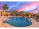 Backyard pool with a waterfall, basketball hoop, and a charming pergola with seating at 3733 E Kachina Dr, Phoenix, AZ 85044