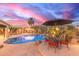 Poolside dining and an umbrella offer a cool place to sit in this backyard oasis at 3733 E Kachina Dr, Phoenix, AZ 85044
