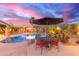 Inviting backyard featuring a sparkling pool, spa, lush landscaping, and a covered patio with outdoor seating at 3733 E Kachina Dr, Phoenix, AZ 85044