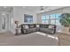 Bright living room featuring a gray leather sectional sofa, large windows, and recessed lighting at 3750 E Rochelle Cir, Mesa, AZ 85215