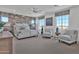 Large main bedroom with brick accent wall, comfortable seating, ceiling fan, and ample natural light at 3750 E Rochelle Cir, Mesa, AZ 85215