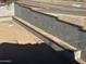 Image shows a tall block retaining wall, tiered with decorative dark brick, alongside a street at 3750 E Rochelle Cir, Mesa, AZ 85215