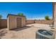 Backyard with a storage shed, gravel, and some greenery at 38662 N La Grange Ln, San Tan Valley, AZ 85140