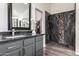 Bathroom featuring a modern vanity, a walk-in shower with black and stone accents at 38662 N La Grange Ln, San Tan Valley, AZ 85140