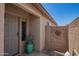 Welcoming front porch area with a potted plant and decorative sunburst wall art at 38662 N La Grange Ln, San Tan Valley, AZ 85140