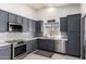 Modern kitchen with stainless steel appliances, gray cabinets, and tiled backsplash at 38662 N La Grange Ln, San Tan Valley, AZ 85140