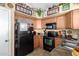 Functional kitchen with ample counter space, cabinets, and black appliances at 43036 W Anne Ln, Maricopa, AZ 85138