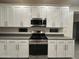 Close-up of a modern kitchen with white cabinets, stainless steel appliances, and stylish countertops with tiled floors at 4440 S Leisure Way, Gilbert, AZ 85297