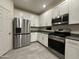 Modern kitchen with stainless steel refrigerator and appliances, white cabinets, and ample counter space at 4440 S Leisure Way, Gilbert, AZ 85297