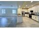 Spacious kitchen featuring stainless steel appliances, white cabinetry, and a breakfast bar open to the living area at 4440 S Leisure Way, Gilbert, AZ 85297