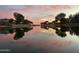 Community pond reflecting the sky, surrounding trees, and homes at 4440 S Leisure Way, Gilbert, AZ 85297