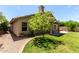 Landscaped backyard featuring green grass, mature tree, and a covered patio at 4544 E Campo Bello Dr, Phoenix, AZ 85032