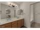 Bathroom featuring double sinks, wooden cabinets, large mirror and walk-in closet at 4544 E Campo Bello Dr, Phoenix, AZ 85032