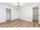 This bedroom has wood floors, an open closet, updated lighting, and an en suite bathroom at 4922 W Coolidge St, Phoenix, AZ 85031