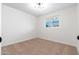 A bright bedroom featuring a brick wall, modern lighting, neutral carpet, and a window view at 4922 W Coolidge St, Phoenix, AZ 85031