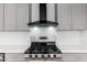 Close-up of a stainless steel stove and vent hood in an updated kitchen with gray cabinets at 4922 W Coolidge St, Phoenix, AZ 85031
