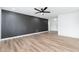 Spacious living room with a dark accent wall, wood-look flooring, and ample natural light at 4922 W Coolidge St, Phoenix, AZ 85031
