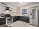 Well-lit kitchen featuring stainless steel appliances and dark cabinets for a modern look at 5159 W Vernon Ave, Phoenix, AZ 85035