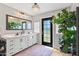 Bright bathroom featuring a double sink vanity, decorative mirror, large plant, and modern lighting fixtures at 5325 E Thunderbird Rd, Scottsdale, AZ 85254