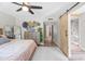 Spacious bedroom with ceiling fan, decorative baskets on the dresser, and a sliding barn door to the bathroom at 5325 E Thunderbird Rd, Scottsdale, AZ 85254