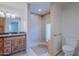 Bathroom featuring double sinks with granite countertops, wood cabinetry, and a tiled shower at 5539 E Dahlia Dr, Scottsdale, AZ 85254