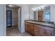Bathroom featuring double sinks with granite countertops, wood cabinetry, and a walk-in closet at 5539 E Dahlia Dr, Scottsdale, AZ 85254