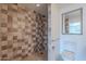 Bathroom featuring tiled walk-in shower, neutral walls, and framed mirror at 5539 E Dahlia Dr, Scottsdale, AZ 85254