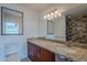 Bathroom vanity featuring granite counters, wood cabinets, modern lighting and framed mirror at 5539 E Dahlia Dr, Scottsdale, AZ 85254