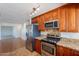A modern kitchen features stainless steel appliances and beautiful wooden cabinets and granite countertops at 5539 E Dahlia Dr, Scottsdale, AZ 85254