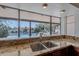 A well-lit kitchen sink with a beautiful window overlooks a sparkling pool and lush greenery at 5539 E Dahlia Dr, Scottsdale, AZ 85254
