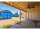 View of backyard with covered patio, blue shed, and dirt ground cover at 717 W Chilton St, Chandler, AZ 85225