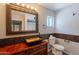 This bathroom features a rustic vanity, attractive mirror, and decorative tile accents at 717 W Chilton St, Chandler, AZ 85225