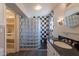 Elegant bathroom showcasing black-and-white tile, glass block wall, black granite countertop, and ample storage space at 717 W Chilton St, Chandler, AZ 85225