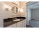 Well-lit bathroom featuring a granite countertop vanity and a large round mirror at 717 W Chilton St, Chandler, AZ 85225