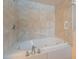 Elegant white soaking tub with tile surround and chrome fixtures, offering a luxurious spa experience at 717 W Chilton St, Chandler, AZ 85225