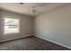 This cozy bedroom offers plush carpeting, a ceiling fan, and a bright window with a pleasant view at 717 W Chilton St, Chandler, AZ 85225
