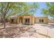 Tan single-story home featuring an arched entryway, desert landscaping, and a concrete driveway at 717 W Chilton St, Chandler, AZ 85225