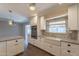 Modern kitchen features stainless appliances, white cabinetry and stone countertops with farmhouse sink at 717 W Chilton St, Chandler, AZ 85225