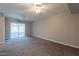 Spacious living room with neutral-toned walls, ceiling fans, and sliding door to sunroom at 717 W Chilton St, Chandler, AZ 85225