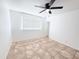 Bedroom featuring neutral tile floor, a window, ceiling fan, and a door at 7202 N 36Th Ave, Phoenix, AZ 85051