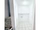 All-white laundry room with tiled floors and overhead cabinets at 7202 N 36Th Ave, Phoenix, AZ 85051