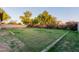 Back yard features a large grassy area with landscaping and perimeter fencing at 7607 W Keim Dr, Glendale, AZ 85303