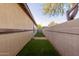 Low-maintenance backyard featuring artificial grass, a brick wall and exterior stucco wall at 7607 W Keim Dr, Glendale, AZ 85303