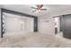 Large bedroom with ceiling fan, gray accent wall, and attached bathroom with sliding barn door at 7607 W Keim Dr, Glendale, AZ 85303