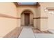 Arched entrance leading to a brown front door framed by desert landscaping at 7607 W Keim Dr, Glendale, AZ 85303
