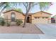 Charming front exterior with manicured landscaping, a two-car garage, and desert-style rock garden at 7607 W Keim Dr, Glendale, AZ 85303