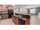 Kitchen with granite countertops, stainless steel appliances, and black refrigerator with island breakfast bar at 7607 W Keim Dr, Glendale, AZ 85303
