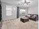 Bright living room with a neutral sofa, a ceiling fan, and slider doors to the backyard at 7607 W Keim Dr, Glendale, AZ 85303