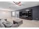 Inviting living room with a media center, a gray sofa, a ceiling fan, and modern touches at 7607 W Keim Dr, Glendale, AZ 85303