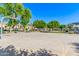 Community basketball court surrounded by lush landscaping, shaded seating areas, and residential buildings at 7769 W Bonitos Dr, Phoenix, AZ 85035